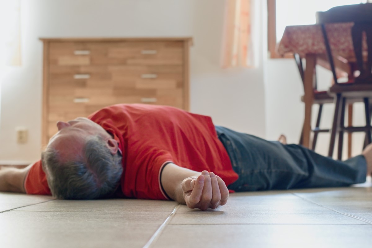 An unconscious man lying on the floor of a house
