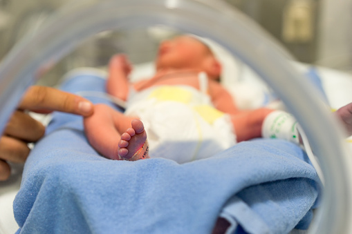 a newborn lying in an incubator