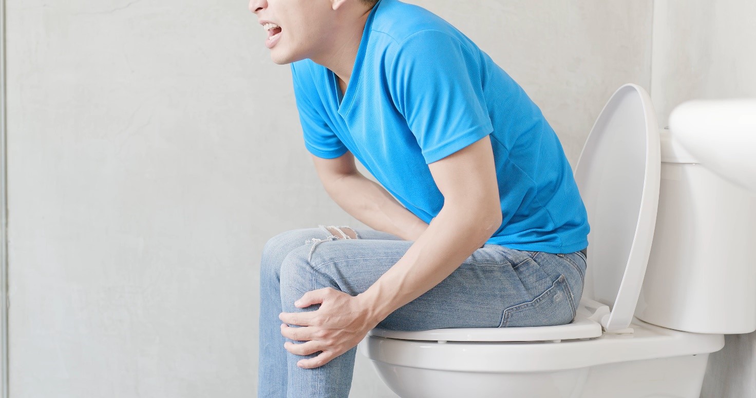 Person sitting on the toilet, has abdominal pain