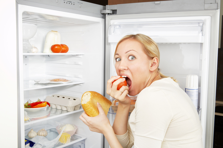 A woman in the refrigerator as a sign of overeating at bulimia