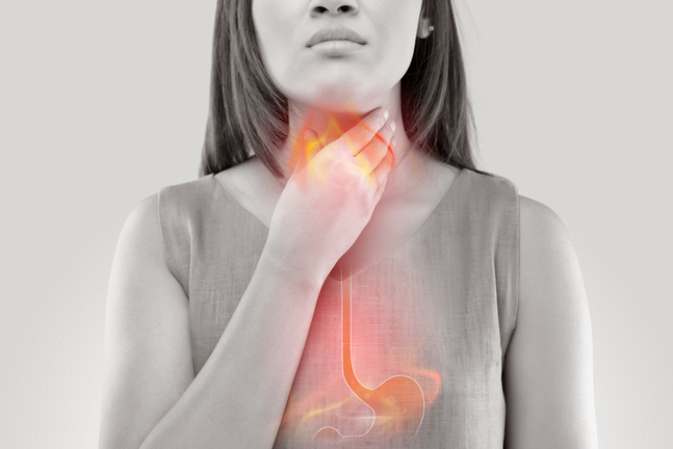 woman holding her neck for heartburn