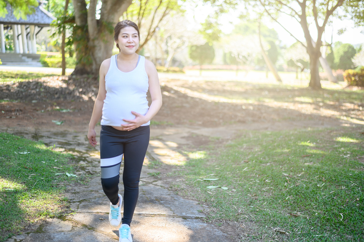 Pregnant woman walking in the park.