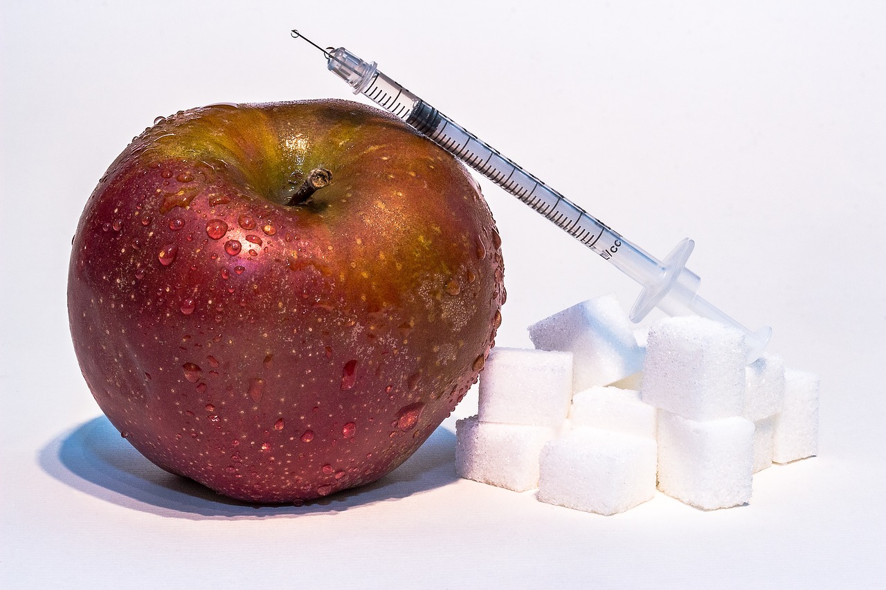 red apple, sugar cubes and insulin syringe
