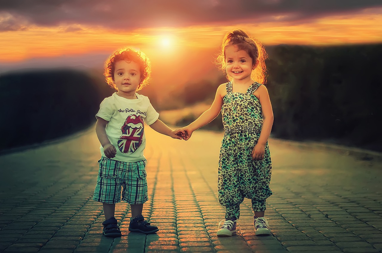 Children, girl and boy holding hands, sun, pavement, laughter, joy