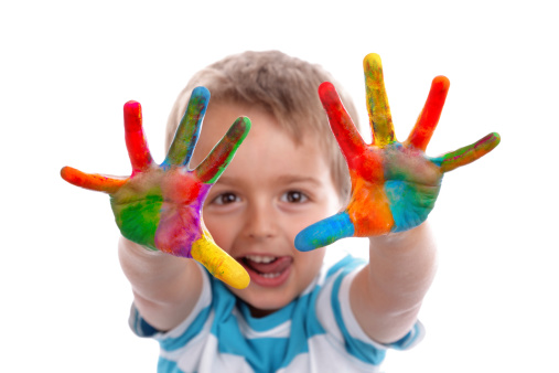 A little boy showing his hands to the lens stained with paint