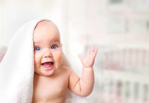 Laughing baby under the blanket