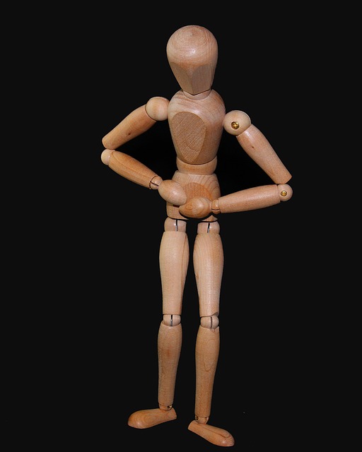 Wooden figure holding his stomach as a sign of abdominal pain