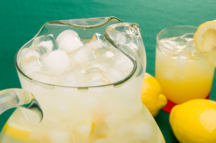 glass pitcher with lemonade and ice cubes