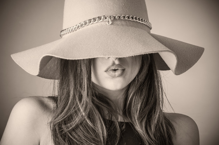 black and white photo of a woman with a big hat