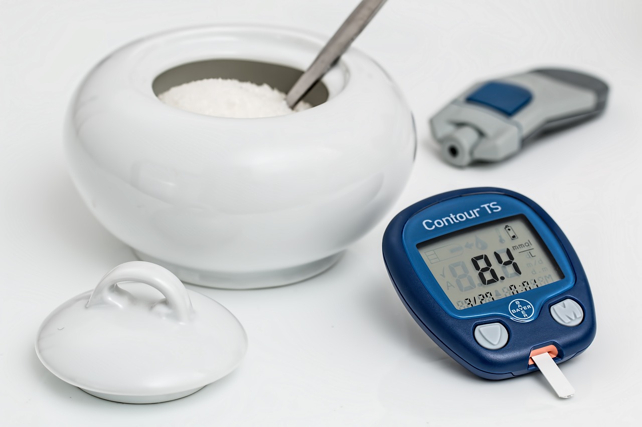 blue glucose meter on the table next to the sugar jar