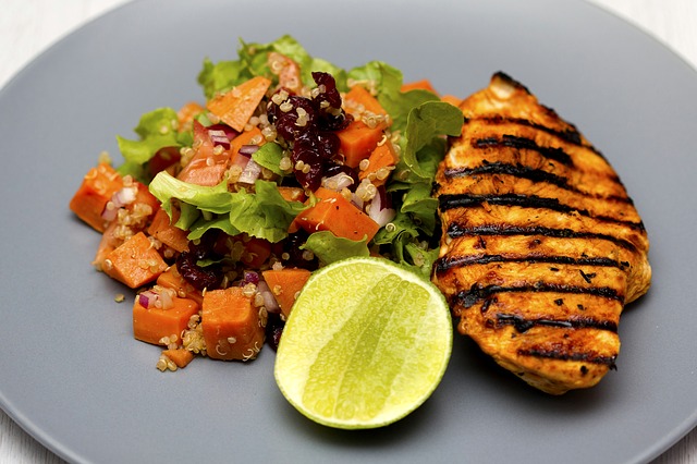 Grilled chicken breast. Grilled vegetables. On a white plate.