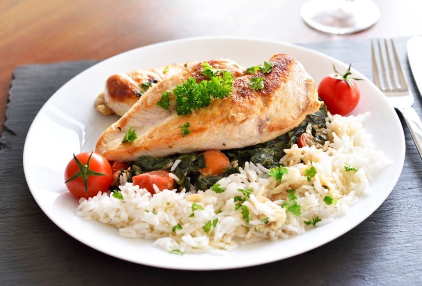 Lunch example: grilled chicken breast with rice, herbs and fresh vegetables.