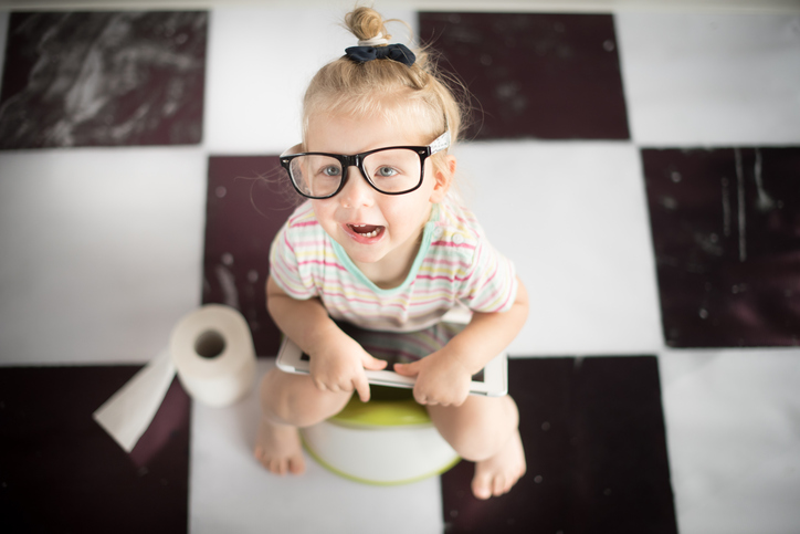 a small child in sunglasses sitting on the potty