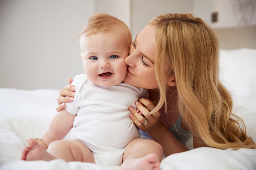 mother kissing her happy child