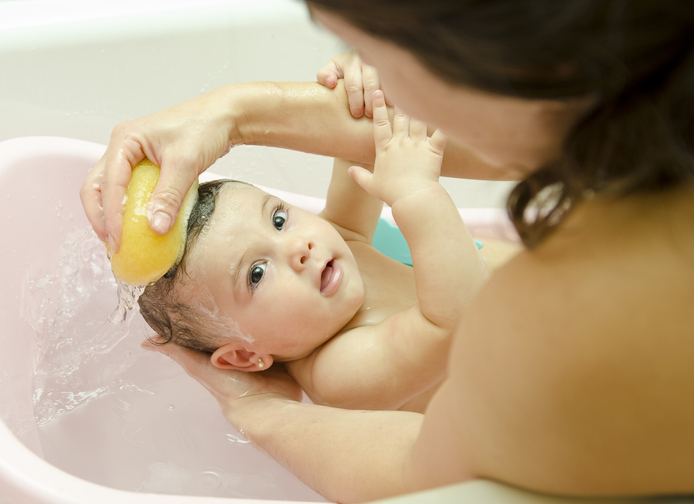 Mother washing her baby in a sponge bath