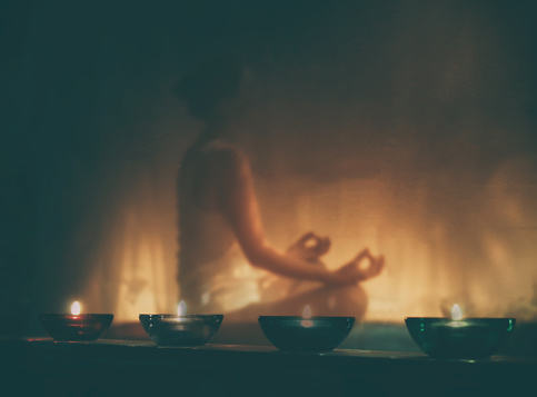 woman meditating by candlelight