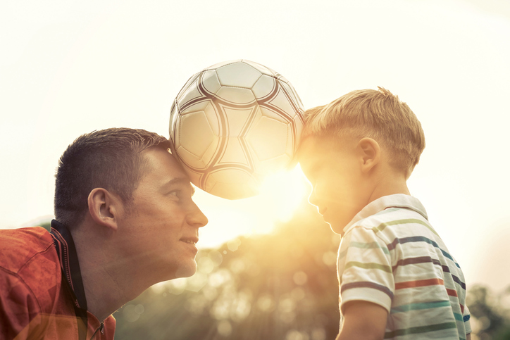 Father and son hold the ball between them.