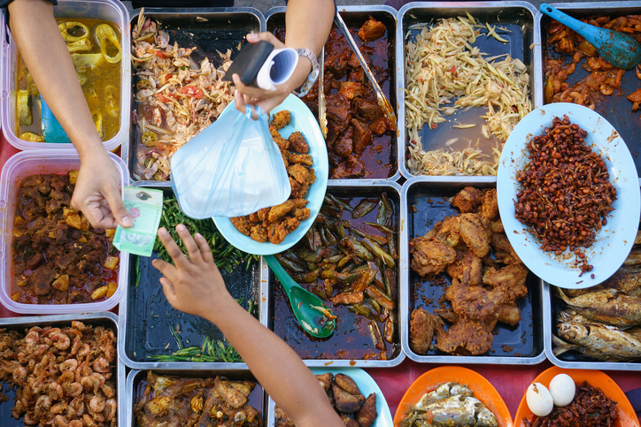 Thai street food, meat, eggs, vegetables, pasta. Money, dirty hands.