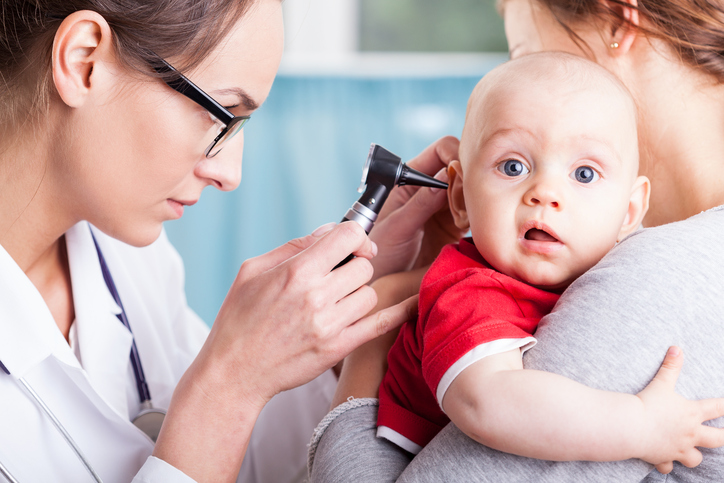 a doctor examines a child's ear with a machine