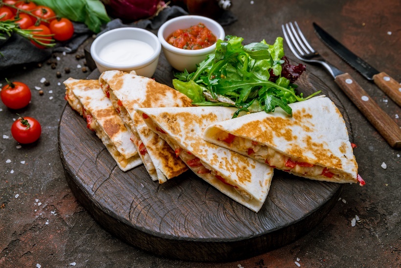 Lunch example: quesadilla baked with meat/beans and vegetables. Side dish with tomato sauce and fresh vegetables