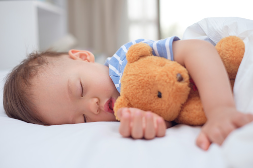 Toddler sleeping with teddy bear