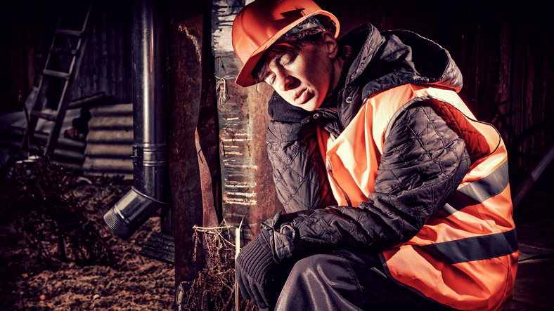 sleeping man at work with red helmet and reflective vest