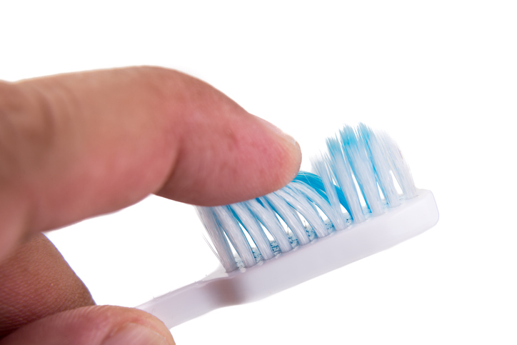 Toothbrush, testing bristle hardness with finger, index finger