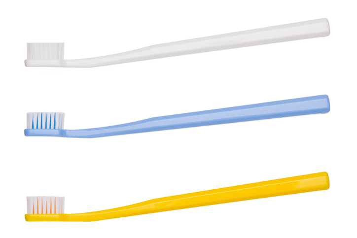 Three suitable toothbrushes, white on top, blue in the middle and yellow on the bottom