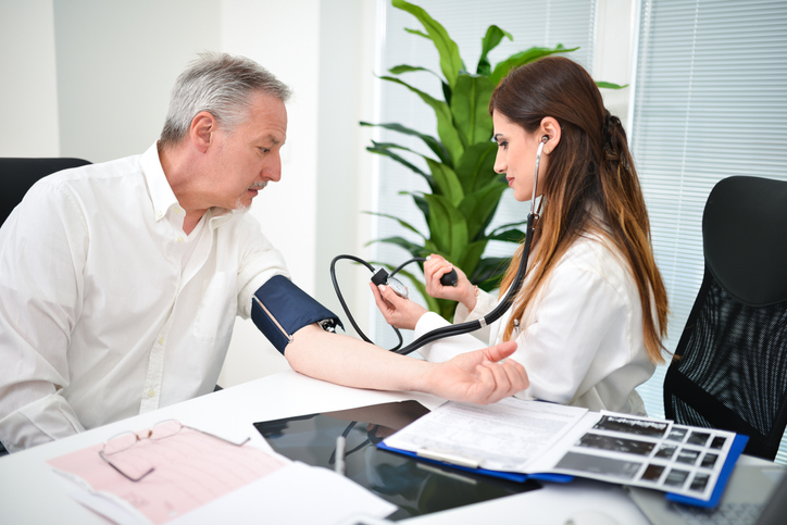 A doctor measures a man's blood pressure