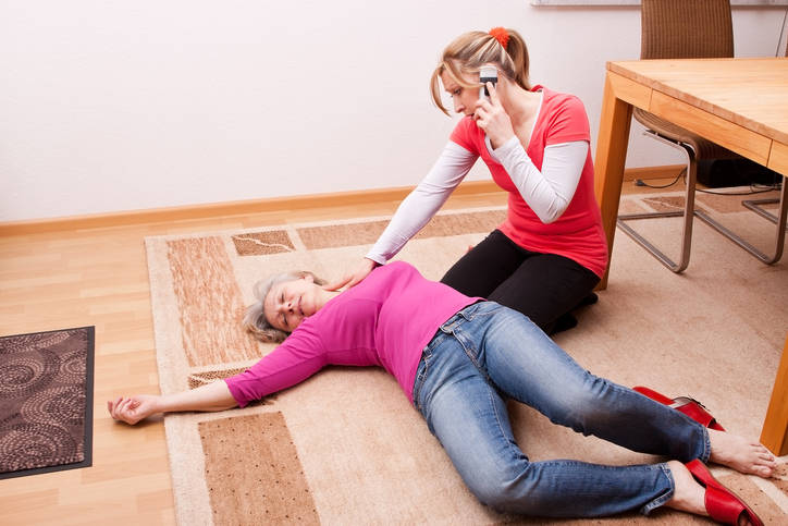 A woman is lying unconscious on the ground. The other woman is calling for help.