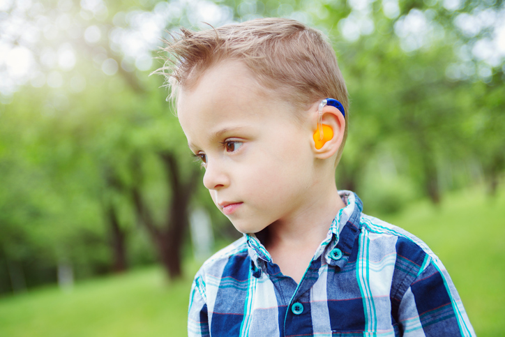 a boy with a color hearing aid, has a hearing loss