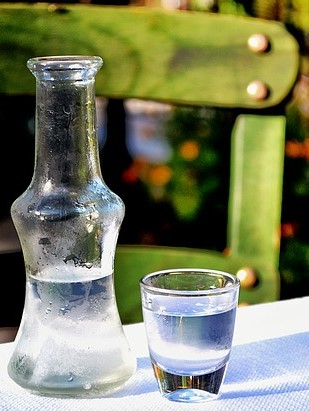 A bottle and glass of hard liquor, home-made schnapps
