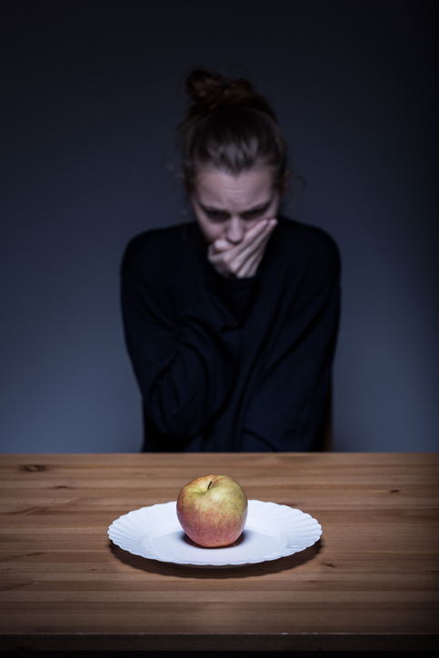 Woman refuses food, there is an apple on the plate, disgusting