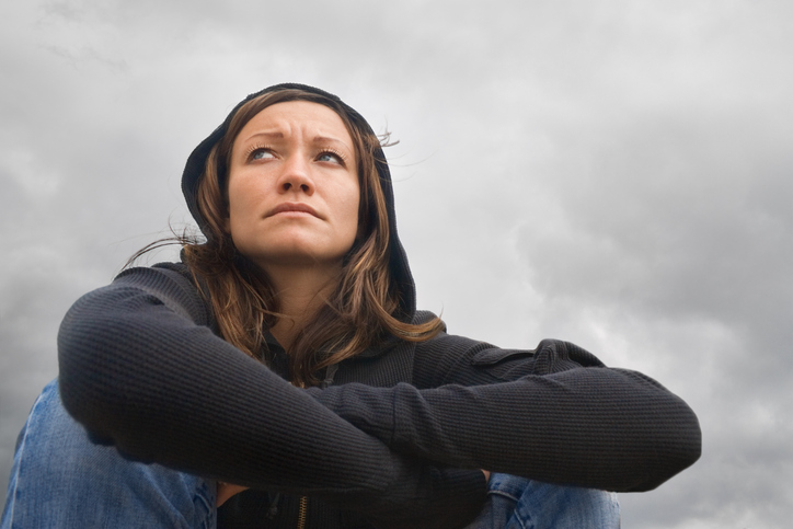 Woman sitting, depressed mood, cloudy weather